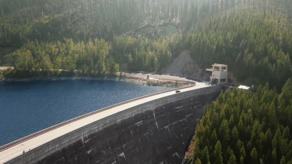 Drone footage of a road with a car on a dam (Hungry Horse Dam, Flathead River, Montana, USA)