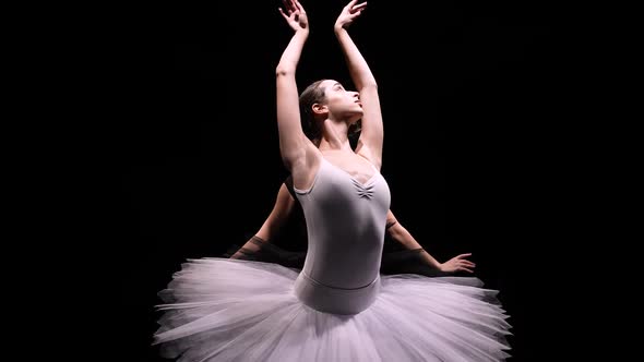 Camera Rotates Around Two Flexible Ballerinas in Black and White Tutus Move Their Hands Dramatically