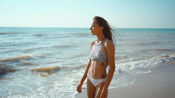 Slow Motion Footage of Happy Joyful Fitness Girl in Bikini Walks Along Sea Beach with Waves