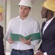 Group of Smiling Builders in Hardhats with Clipboard and Blueprint Outdoors - VideoHive Item for Sale