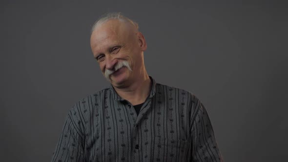 Calm Senior Man Smiles Crosses Arms and Listens Attentively