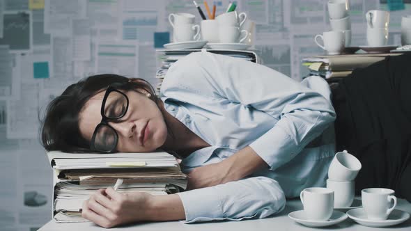Exhausted businesswoman sleeping on the desk