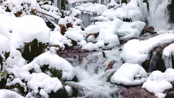 Small Streams of Cold Water Flow Among the Stones Covered with Snow