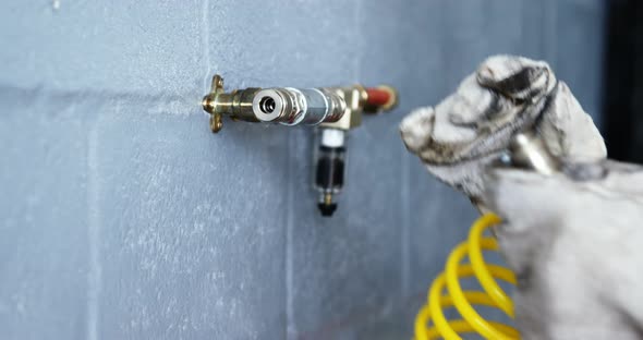 Hands of mechanic connecting a wire to spray nozzle
