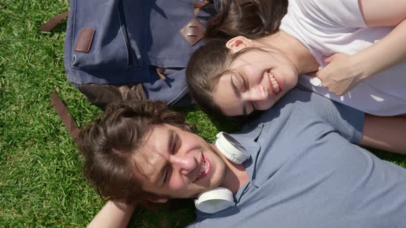 Top View of Romantic Young Couple Resting on Grass in Park