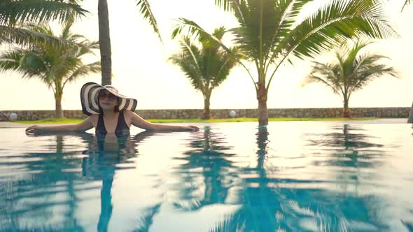 Young asian woman enjoy around outdoor swimming pool for leisure