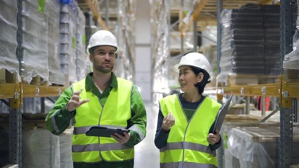 Young American Employees Having Conversation and Walking on Plant Warehouse While Working