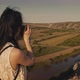 Young female tourist taking a photo of a picturesque canyon in the summer. - VideoHive Item for Sale