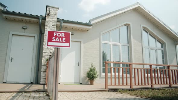 Beautiful Modern House in Suburban Area with for Sale Sign on Sunny Summer Day