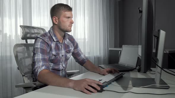 Handsome IT Office Worker Using Two Computers Working on a Project