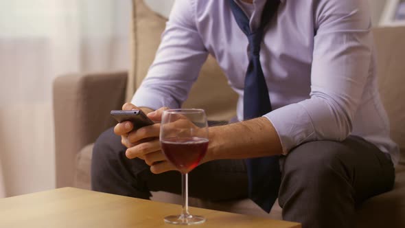 Alcoholic with Smartphone Drinking Wine at Home