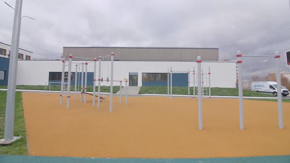 Empty Sports Ground with Exercise Bars Near Athletic Center