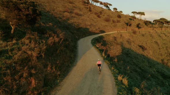 Drone Footage of Woman Cyclist in Sunset on Bike