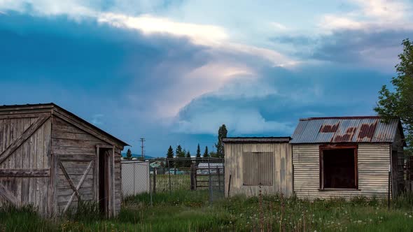 Storm clouds building in the sky over old farm sheds