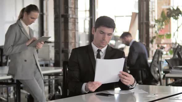 Businessman Reading Contract Paperwork