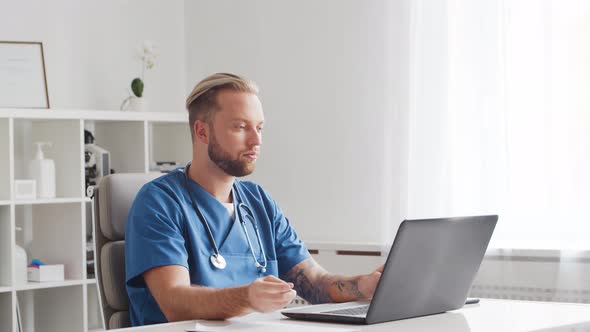 Professional medical doctor is working in hospital office using computer.