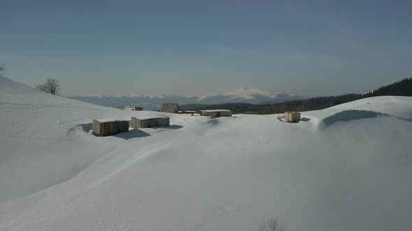 Aerial View of an Alpine Settlement on a Background of Snowcovered Winter Mountains