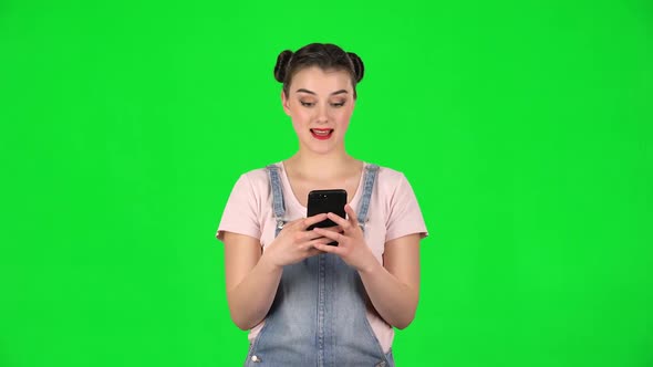Young Smiling Woman Texting on Her Phone on Green Screen