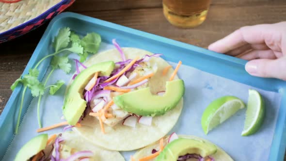 Fresh fish tacos with cod and purple cabbage on a white corn tortillas.