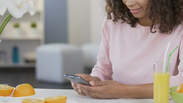 Smiling Biracial Girl Scrolling on Smartphone and Using Diet Application, Health