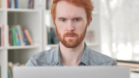 Close Up of Casual Redhead Man Working On Laptop