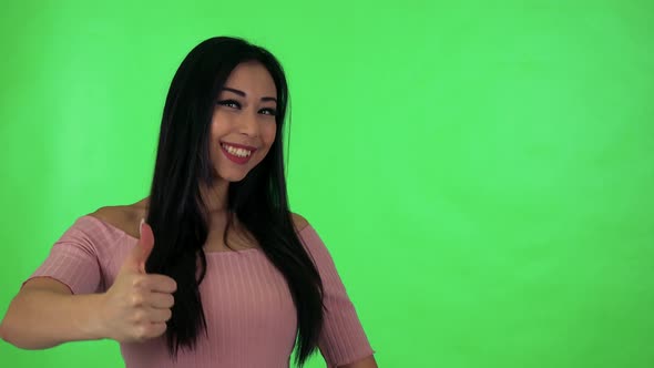 Young Attractive Asian Woman Shows Thumb on Agreement - Green Screen Studio