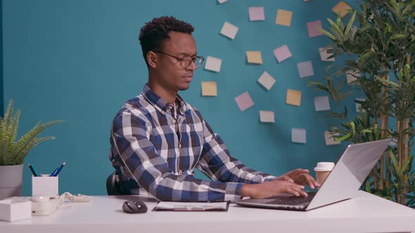 Office Employee Giving Thumbs Down in Front of Laptop Screen