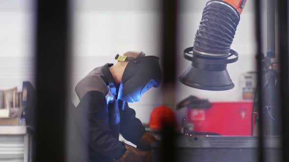 Skillful Worker Welding in Industrial Factory