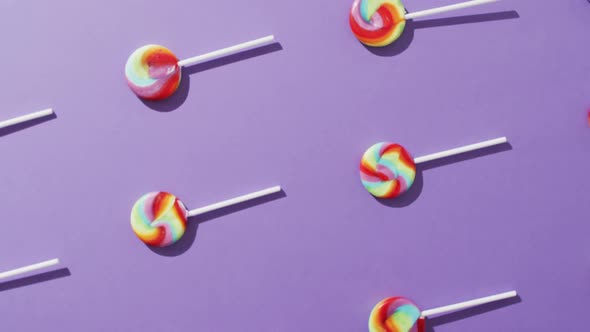Video of rows multicoloured lollipops on blue background