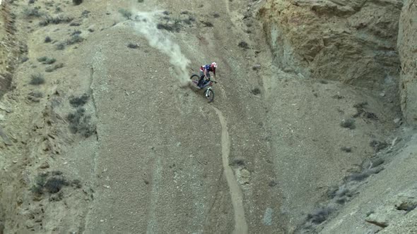 Slow motion of guy riding mountain bike down steep dirt hill.