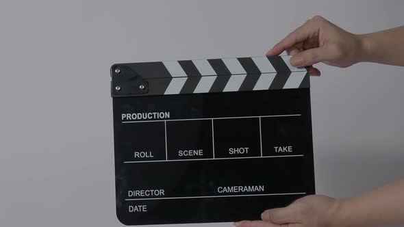 Clapper board. Close up hand and film making clapperboard isolated on background studio.