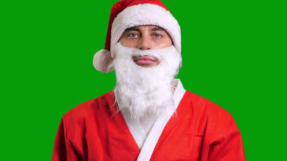 Santa Claus in Red Suit Pointing Aside to the Corner on Green Chroma Key Background