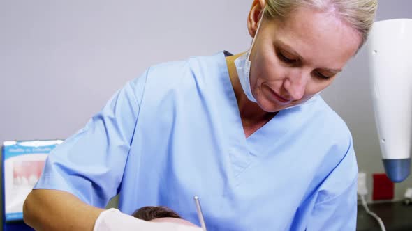 Dentist examining a male patient with dental tools