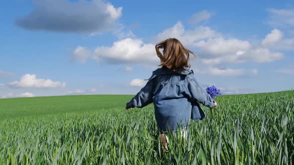 An 11Yearold Child Girl Runs Across a Field with Tall Green Grass