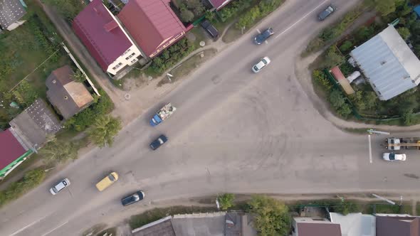 Aerial View of a City Intersection with Moving Cars and Onestory Houses