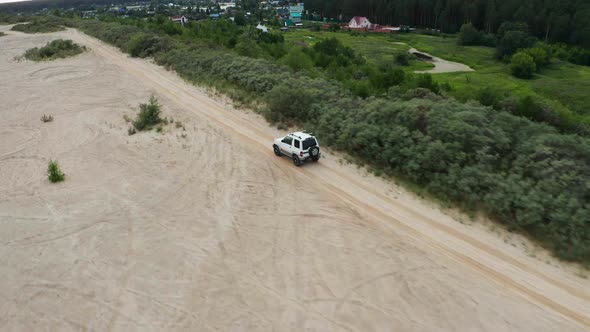 Aerial View of a Car Driving on Sand