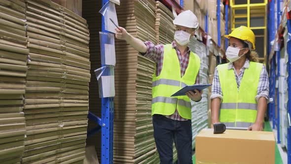 Group of diversity worker wear safety helmet and face mask working in warehouse during covid19.