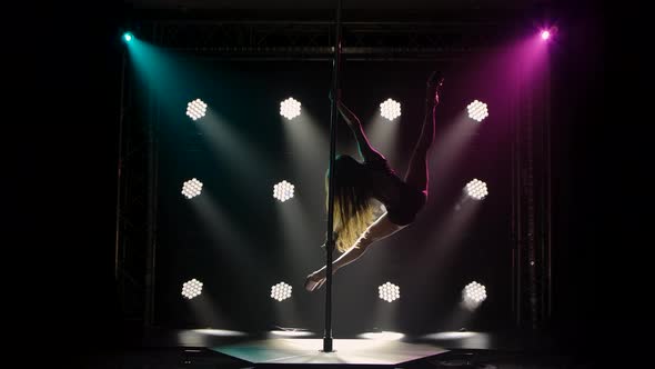 Professional Pole Dancer Performs Tricks While Spinning on a Pole Splitting and Walking in the Air