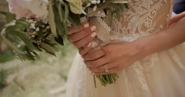 Female hands  holds a wedding bouquet. Bride with flowers