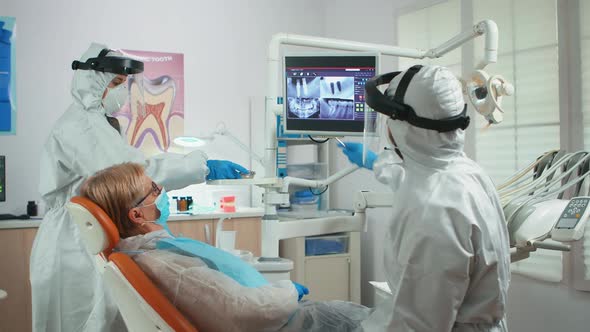 Orthodontist in Special Equipment Pointing on Digital Xray