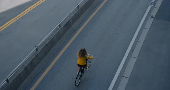 Woman Rides Bike on Bike Lane Next To Big Car Road