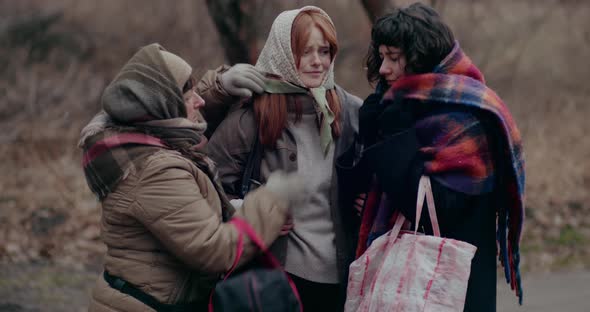 Female Homeless Refugees Consoling During Snowfall