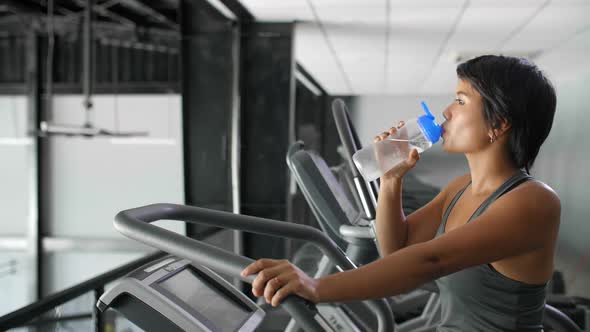 Asian Woman Drinking Water in Gym