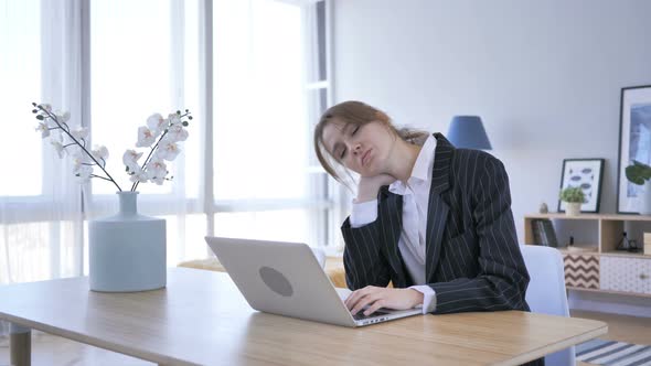 Tired Young Woman Working on Laptop in Office