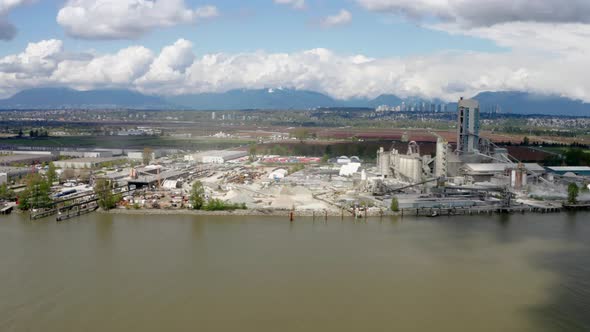 Cement Factory In Industrial Area On The Bank Of Fraser River In Richmond, BC, Canada. wide aerial