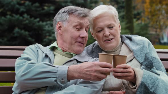 Happy Senior Aged Couple Talking Sit in Autumn Park Rest Together Carefree Elderly Grandparents