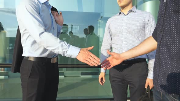 Three Businessmen Greeting Each Other in Urban Environment