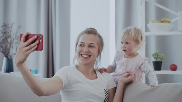 Portrait of Beautiful Mother and Baby Taking a Selfie at Home