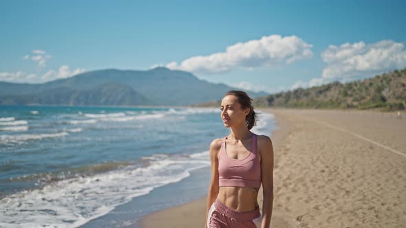 Young Active Sporty Athlete Smiling Woman is Taking a Break After Making Running and Jogging Workout