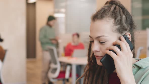 Businesswoman in Dreadlocks Talking on Mobile Phone